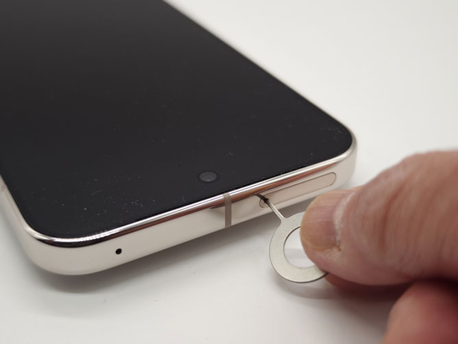 電源がオフになったら、SIMカードスロットの脇にある穴にピンを「垂直」に差し込み、そのままグッと押し込みます。